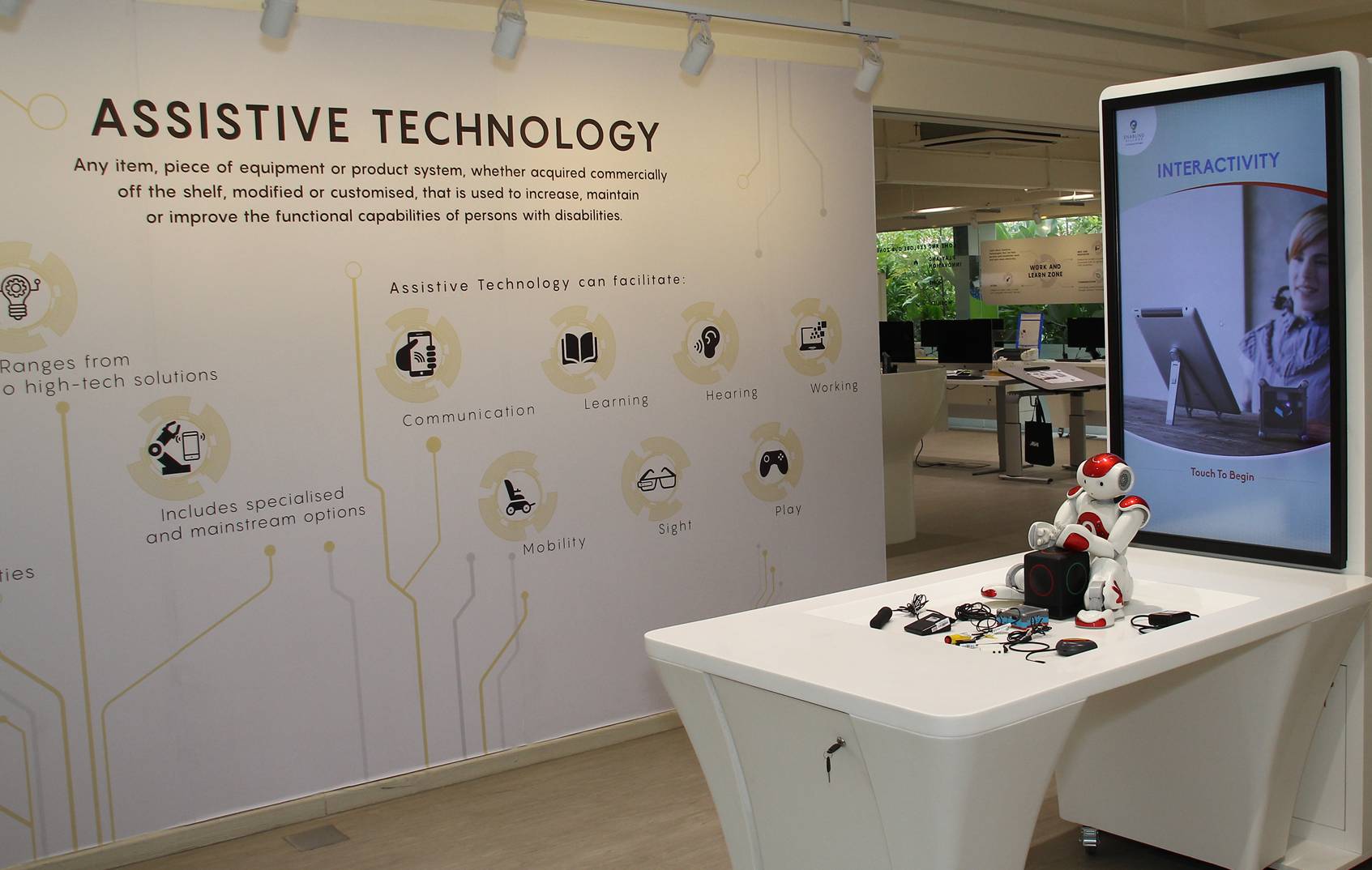 Interior of Tech Able showing digital screens and some assistive technology devices on display like a robot for self-exploration.